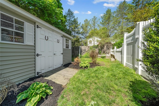 view of yard featuring fence and an outbuilding