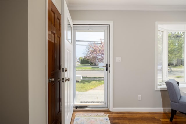 foyer entrance featuring ornamental molding, wood finished floors, and baseboards