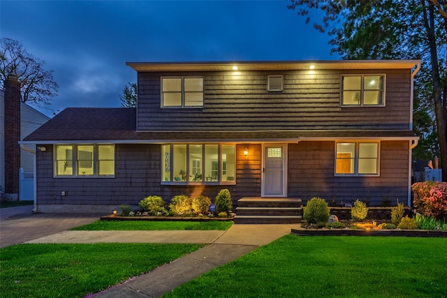 view of front of property with a front yard and roof with shingles