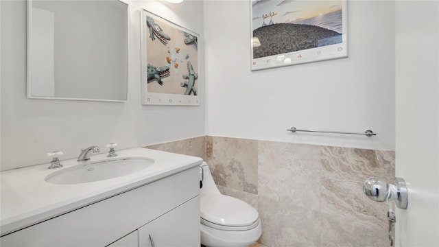 575 Dune Rd Unit 36And 37, Westhampton Beach, NY 11978 - bathroom featuring tile walls, toilet, vanity, and a wainscoted wall