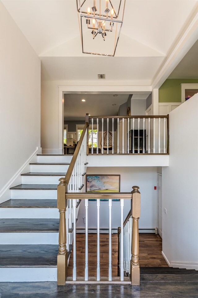 60 Bayview Dr, Huntington, NY 11743 - stairway with an inviting chandelier, wood finished floors, visible vents, baseboards, and lofted ceiling