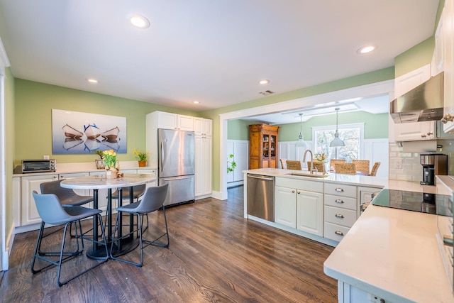 60 Bayview Dr, Huntington, NY 11743 - kitchen featuring a sink, a peninsula, stainless steel appliances, under cabinet range hood, and white cabinets