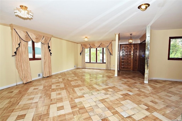 interior space featuring a healthy amount of sunlight, crown molding, baseboards, and visible vents