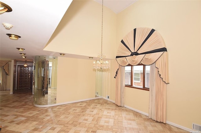interior space with lofted ceiling, a notable chandelier, baseboards, visible vents, and tile patterned floors