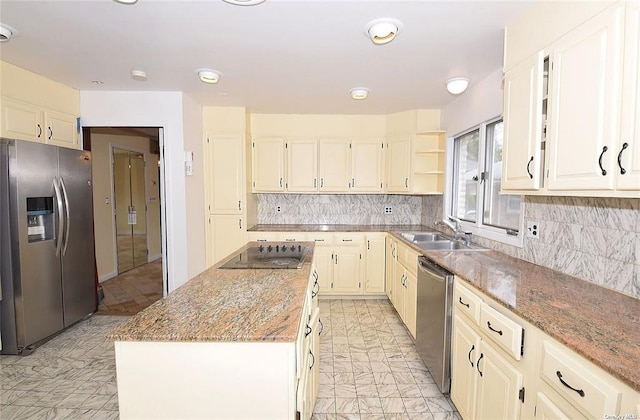 kitchen with a sink, backsplash, a center island, and appliances with stainless steel finishes