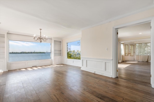 22 Shorecliff Pl, Great Neck, NY 11023 - unfurnished dining area featuring a decorative wall, built in shelves, crown molding, wood-type flooring, and a notable chandelier