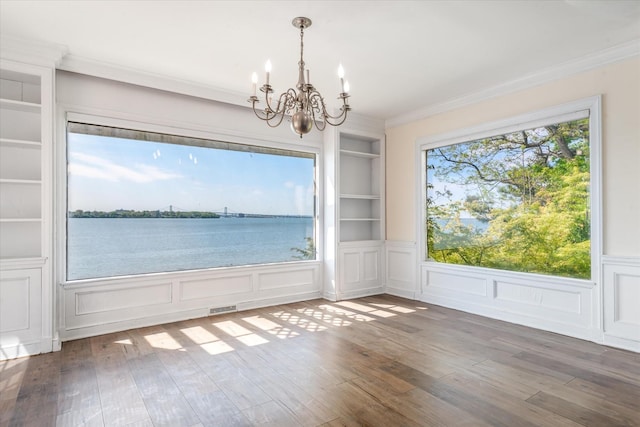 22 Shorecliff Pl, Great Neck, NY 11023 - empty room with a notable chandelier, visible vents, built in shelves, crown molding, and wood finished floors