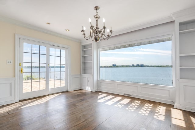 22 Shorecliff Pl, Great Neck, NY 11023 - unfurnished dining area featuring a water view, visible vents, a chandelier, built in shelves, and ornamental molding