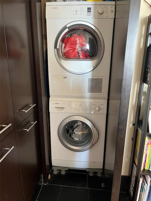 40 Broad St Unit 28H, New York Manhattan, NY 10004 - laundry room with stacked washing machine and dryer and tile patterned floors