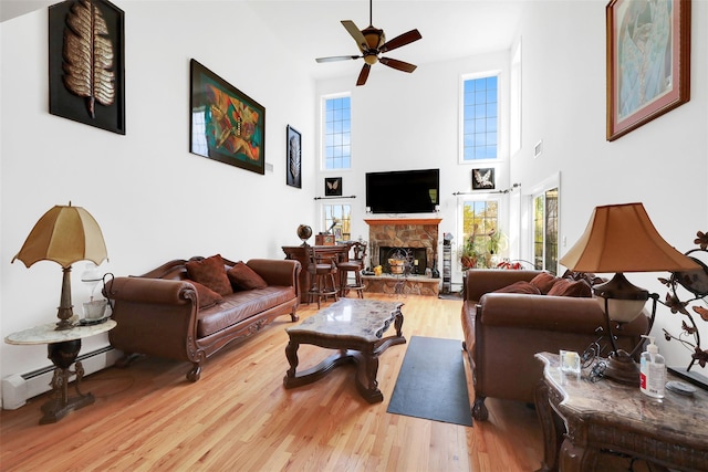14 Clarks Ln, Milton, NY 12547 - living room with wood finished floors, ceiling fan, a stone fireplace, plenty of natural light, and a high ceiling
