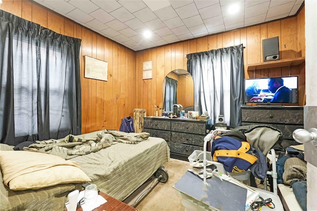 carpeted bedroom featuring wooden walls
