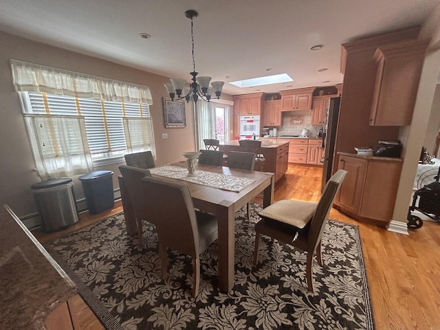 36 Shore Dr W, Copiague, NY 11726 - dining room featuring light wood finished floors and a chandelier