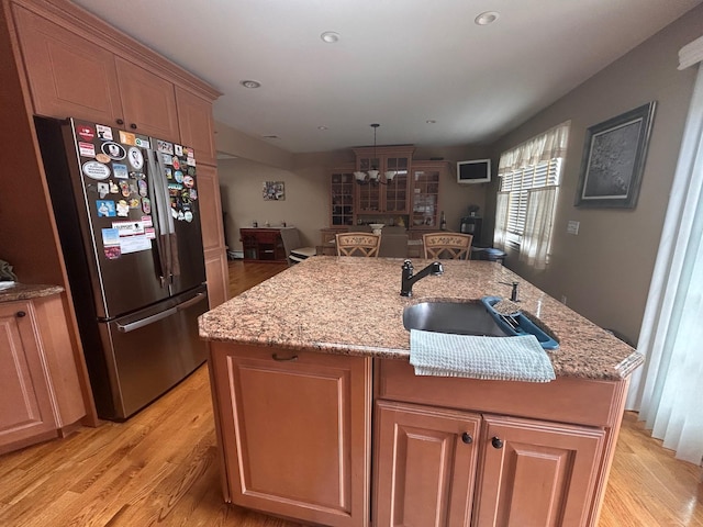 36 Shore Dr W, Copiague, NY 11726 - kitchen with freestanding refrigerator, an island with sink, light wood-type flooring, and a sink