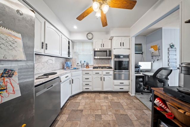 9702 159th Ave, Howard Beach, NY 11414 - kitchen featuring appliances with stainless steel finishes, a warming drawer, tasteful backsplash, white cabinetry, and a ceiling fan