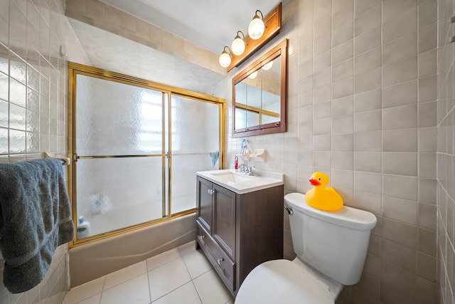9702 159th Ave, Howard Beach, NY 11414 - full bath featuring tile walls, vanity, toilet, tile patterned flooring, and bath / shower combo with glass door