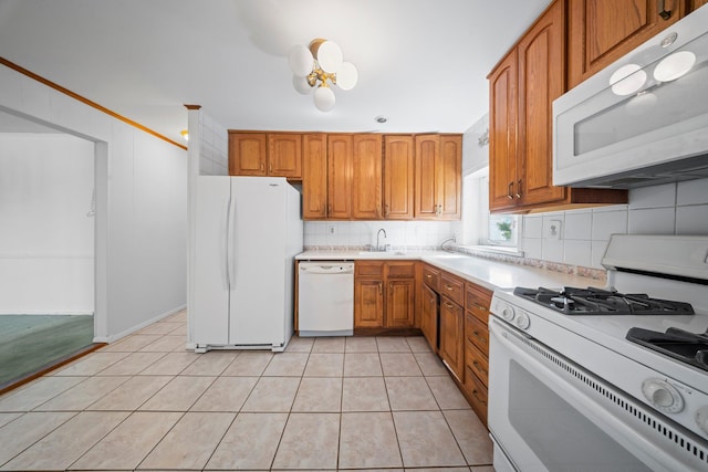 9702 159th Ave, Howard Beach, NY 11414 - kitchen featuring white appliances, a sink, light countertops, tasteful backsplash, and brown cabinets