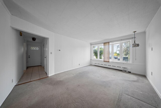 9702 159th Ave, Howard Beach, NY 11414 - carpeted empty room featuring baseboard heating and baseboards