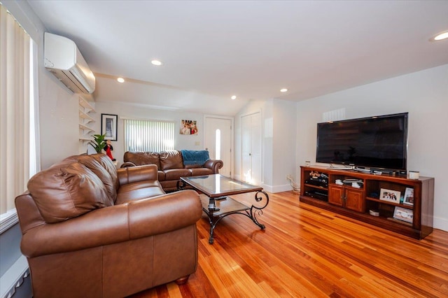 living area with recessed lighting, an AC wall unit, baseboards, and light wood-style floors
