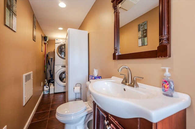 half bathroom featuring heating unit, stacked washer / dryer, toilet, tile patterned floors, and recessed lighting
