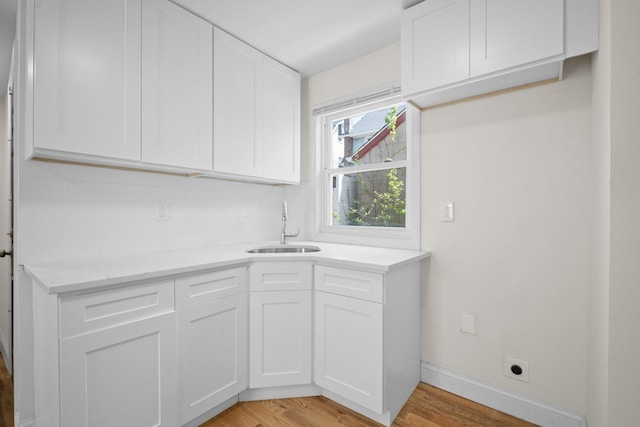 119-47 191st St, Saint Albans, NY 11412 - washroom featuring a sink, indoor wet bar, hookup for an electric dryer, light wood finished floors, and baseboards