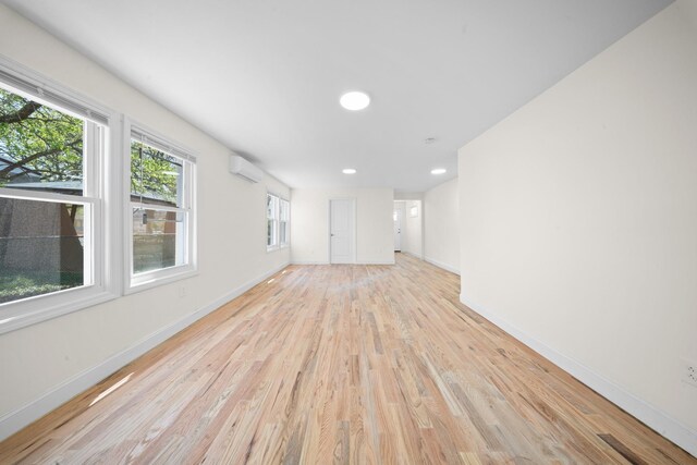119-47 191st St, Saint Albans, NY 11412 - unfurnished living room with baseboards, light wood-style flooring, recessed lighting, and an AC wall unit
