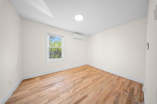 119-47 191st St, Saint Albans, NY 11412 - spare room with baseboards, a wall unit AC, and light wood-style floors