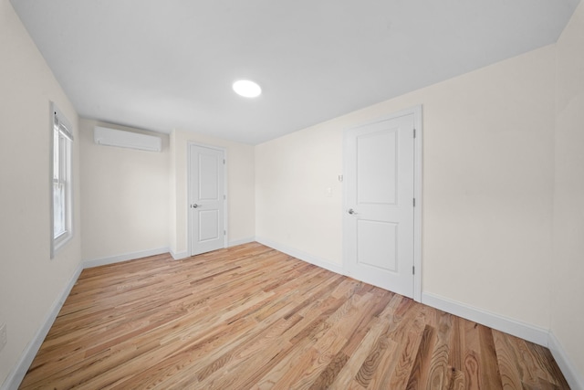119-47 191st St, Saint Albans, NY 11412 - unfurnished bedroom featuring baseboards, light wood-type flooring, and a wall unit AC