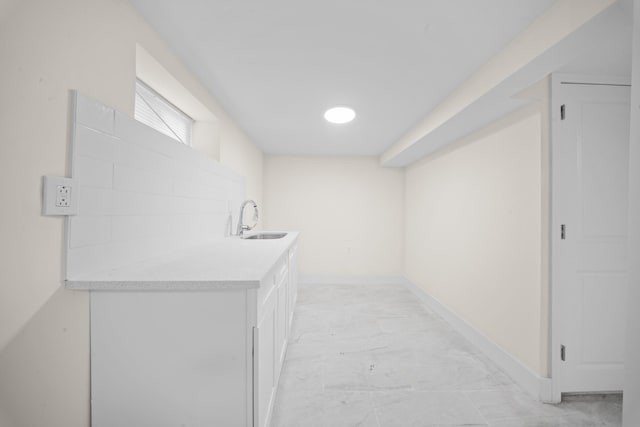 119-47 191st St, Saint Albans, NY 11412 - below grade area with a sink, baseboards, and marble finish floor