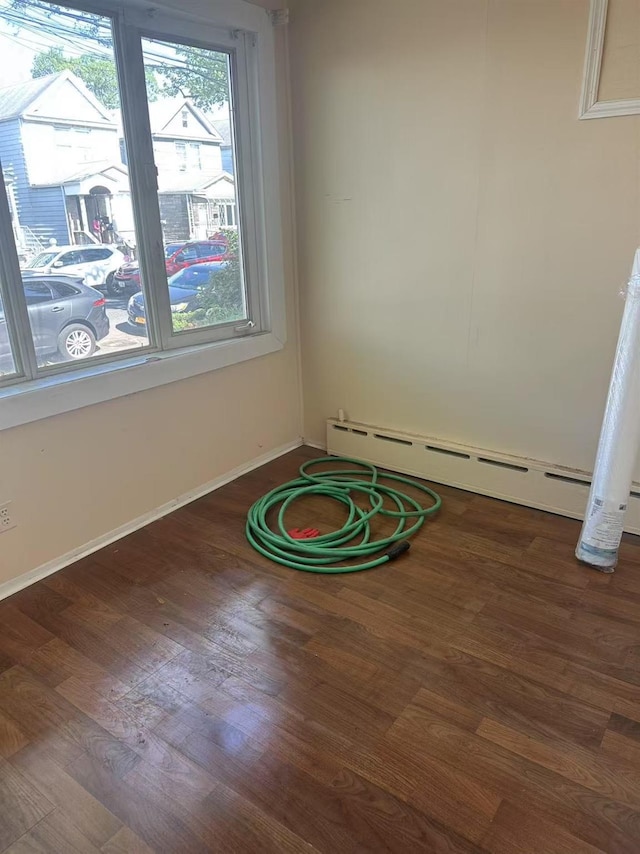 97-22 84th St, Ozone Park, NY 11416 - empty room with baseboards, a baseboard radiator, and wood finished floors