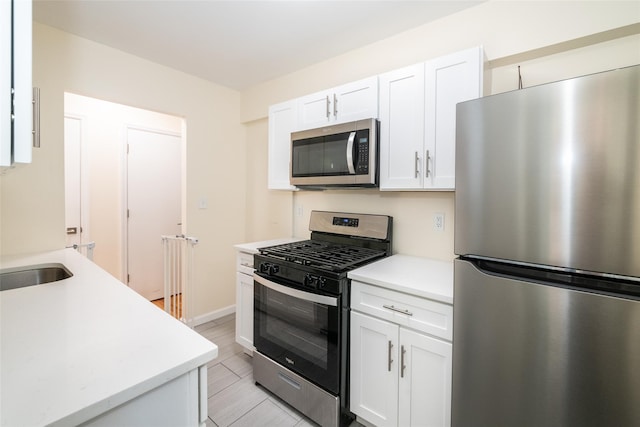 90 Union St Unit 1A, New Rochelle, NY 10801 - kitchen featuring appliances with stainless steel finishes, light countertops, white cabinetry, and baseboards