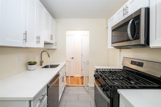 90 Union St Unit 1A, New Rochelle, NY 10801 - kitchen with appliances with stainless steel finishes, a sink, white cabinets, baseboards, and light stone counters