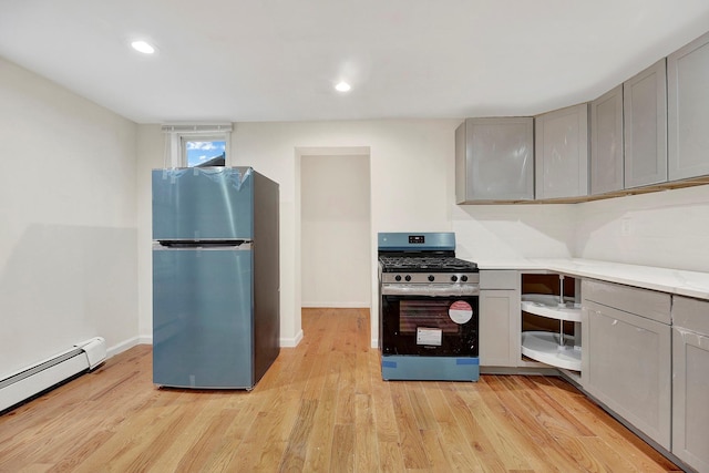 kitchen featuring light wood-style flooring, stainless steel appliances, gray cabinets, light countertops, and a baseboard radiator