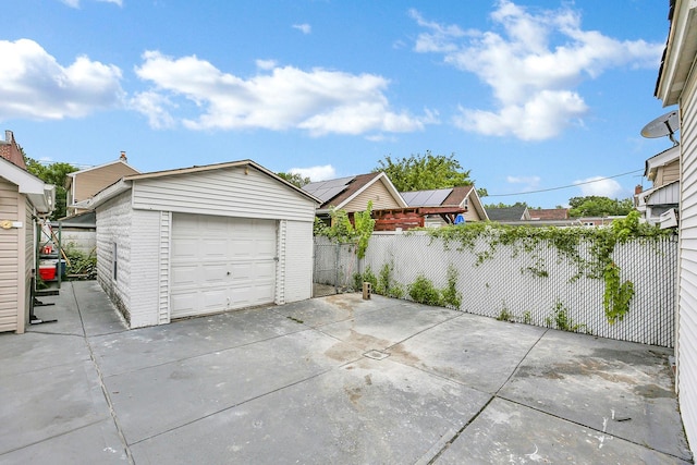 detached garage featuring driveway and fence