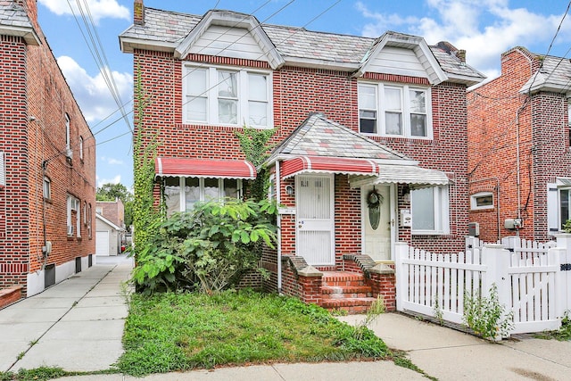 townhome / multi-family property with fence, a garage, a high end roof, and brick siding