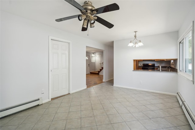 unfurnished room with baseboard heating, stairs, a ceiling fan, and a chandelier