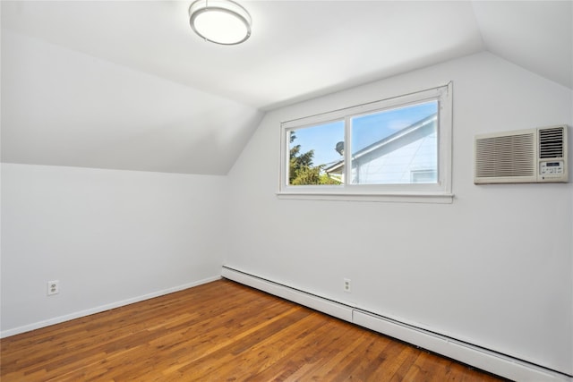 bonus room featuring a baseboard heating unit, vaulted ceiling, an AC wall unit, wood finished floors, and baseboards