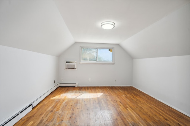 bonus room with baseboard heating, hardwood / wood-style flooring, lofted ceiling, a wall unit AC, and baseboards