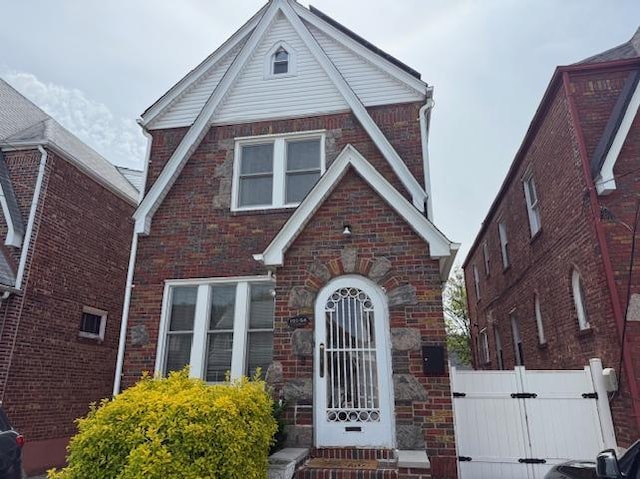 191-54 115th Rd, Saint Albans, NY 11412 - tudor-style house with brick siding, fence, and a gate
