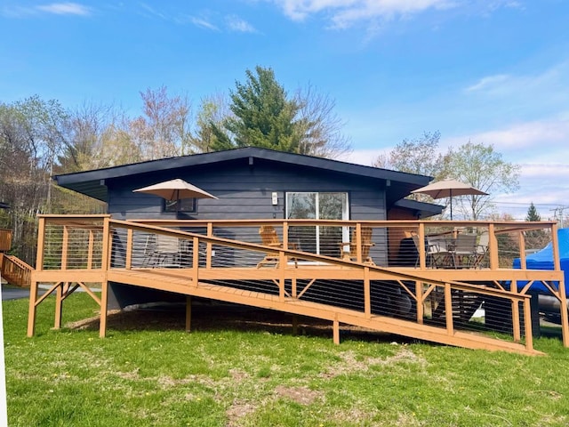 back of property featuring a yard and a wooden deck