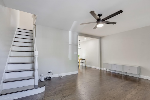 unfurnished living room featuring stairway, ceiling fan, baseboards, and wood finished floors