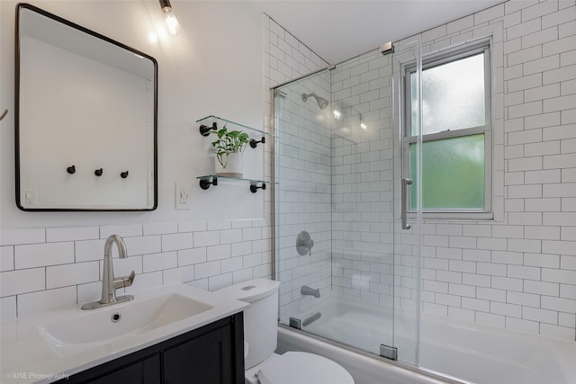 full bath featuring enclosed tub / shower combo, tile walls, vanity, and toilet