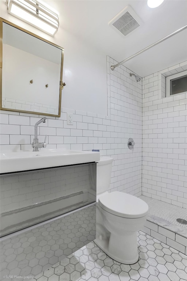 bathroom featuring a stall shower, tile walls, tile patterned flooring, and visible vents