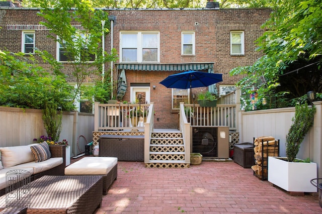 back of house featuring brick siding, a patio, a fenced backyard, a wooden deck, and an outdoor hangout area