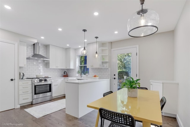 kitchen with stainless steel range with gas cooktop, tasteful backsplash, white cabinetry, and wall chimney exhaust hood