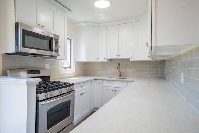 6 Pompano Ln, Massapequa Park, NY 11762 - kitchen featuring stainless steel appliances, a sink, tasteful backsplash, white cabinets, and light stone counters