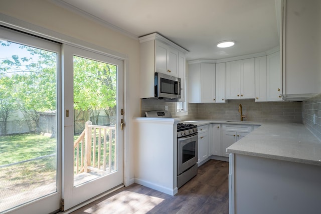 6 Pompano Ln, Massapequa Park, NY 11762 - kitchen featuring stainless steel appliances, backsplash, white cabinetry, a sink, and dark wood-style flooring