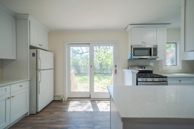 6 Pompano Ln, Massapequa Park, NY 11762 - kitchen featuring appliances with stainless steel finishes, dark wood-style floors, healthy amount of natural light, white cabinetry, and ornamental molding
