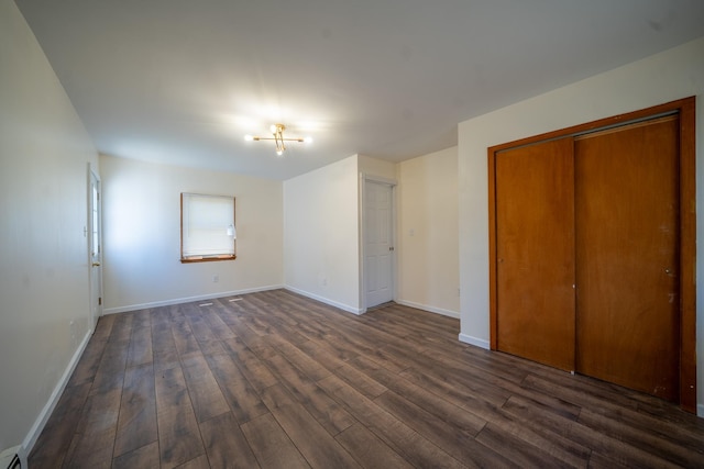 6 Pompano Ln, Massapequa Park, NY 11762 - unfurnished bedroom featuring dark wood finished floors, baseboards, and a closet