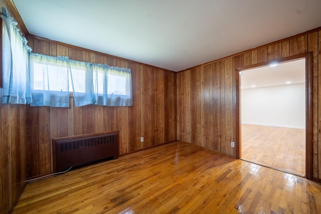6 Pompano Ln, Massapequa Park, NY 11762 - empty room featuring radiator heating unit, wood finished floors, and wood walls