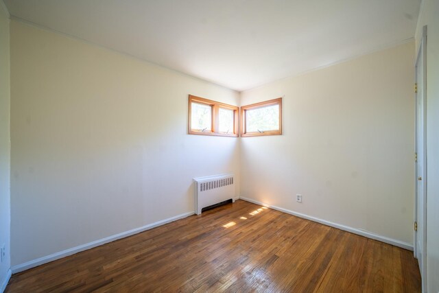 6 Pompano Ln, Massapequa Park, NY 11762 - empty room with radiator heating unit, wood finished floors, and baseboards